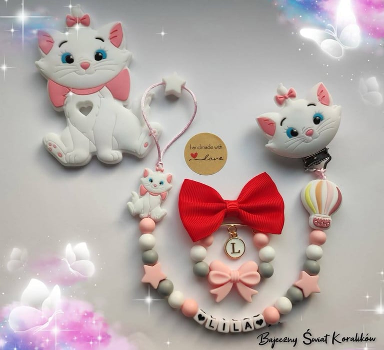 Collection of white cat plushies and beaded pacifier clips with pink bows and beads on sparkly background